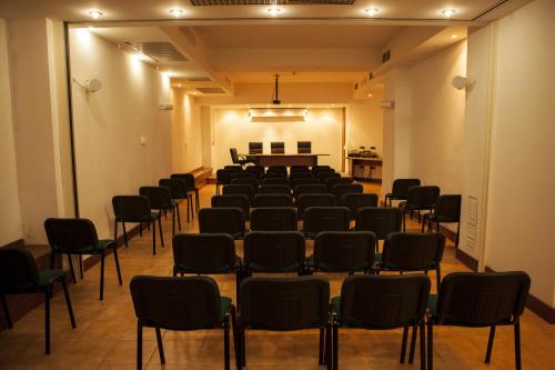 a room with rows of chairs and a piano at Hotel Piccada in Palau