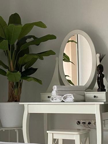 a white table with a mirror and a plant on it at Penzión a Reštaurácia Harmónia Ostratice in Malé Ostratice