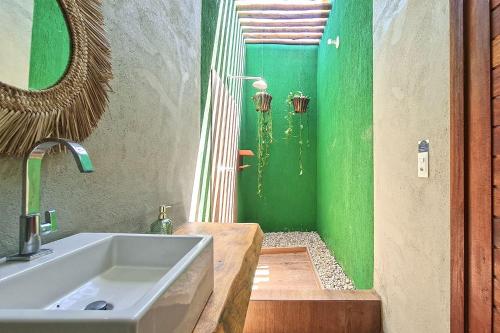 ein Badezimmer mit einem Waschbecken und einer grünen Wand in der Unterkunft Casa em Jijoca de Jericoacoara por Carpediem in Jijoca de Jericoacoara