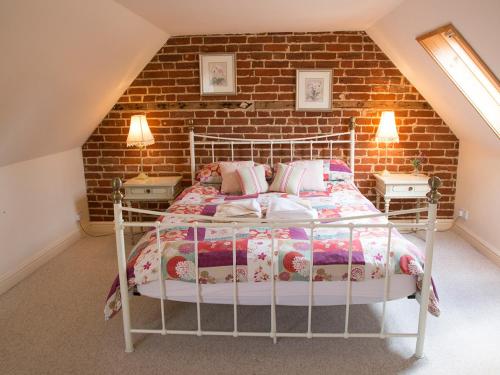a bedroom with a bed and a brick wall at Old Dairy - Ukc3169 in Walpole