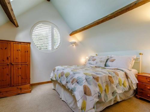 a bedroom with a bed and a window at Charming 2-Bed Cottage in Toft Knutsford in Knutsford