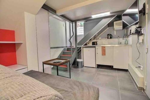une chambre avec un lit et une cuisine avec un escalier dans l'établissement Studio neuf - Gare d'Aulnay, à Aulnay-sous-Bois