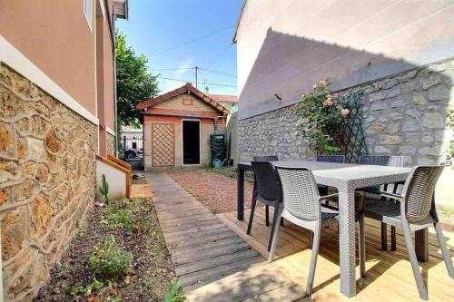 un patio avec une table et des chaises et un bâtiment dans l'établissement Studio neuf - Gare d'Aulnay, à Aulnay-sous-Bois