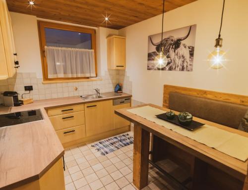 a kitchen with wooden cabinets and a counter top at Alpinchalet Apartment Alpenrose in Ortisei