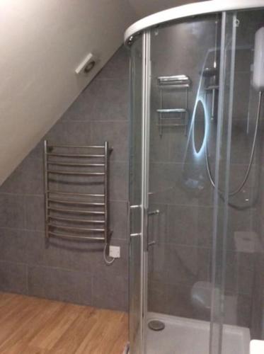 a shower with a glass door in a bathroom at Country Studio Apartment in Charlton