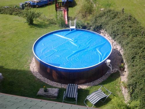 uma vista sobre uma grande piscina na relva em Penzion Iva em Tanvald