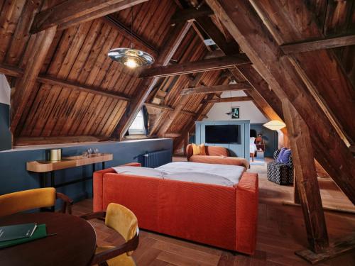 Un dormitorio con una cama roja en una habitación con techos de madera. en The Hoxton, Lloyd Amsterdam en Ámsterdam