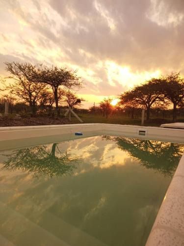 a reflection of the sunset in a swimming pool at "AGUAPÉ" Alojamiento rural con PILETA in Chajarí