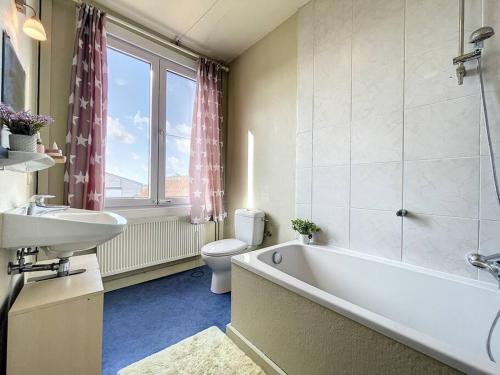 La salle de bains est pourvue d'une baignoire, de toilettes et d'un lavabo. dans l'établissement Holiday Home Sungarden, à Middelkerke