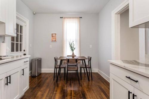 a kitchen with white cabinets and a table with chairs at The Santiago Yale New Haven with Parking and Modern in New Haven