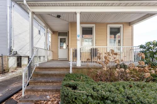 a house with a porch and stairs in front of it at The Santiago Yale New Haven with Parking and Modern in New Haven