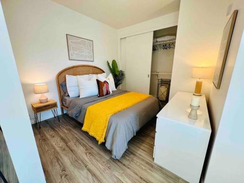 ein Schlafzimmer mit einem Bett mit einer gelben Decke und 2 Lampen in der Unterkunft Lovely open one bedroom in West Oakland in Oakland