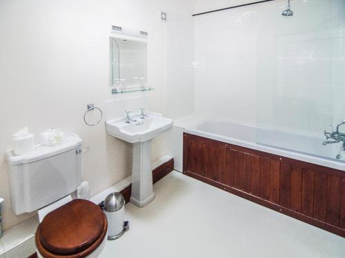 a bathroom with a sink and a tub and a toilet at Kingfisher Barn in Sculthorpe