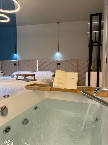 ein Bad mit einer Badewanne, Büchern und einem Bett in der Unterkunft VILLA CHIARA in Torre Orsina