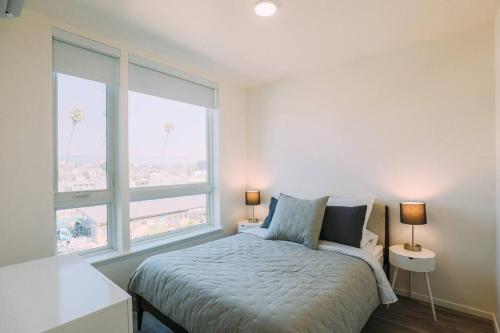 um quarto branco com uma cama e 2 janelas em Luxury 1 Bedroom unit in West Oakland em Oakland