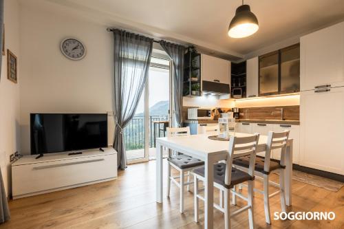 a kitchen and dining room with a white table and chairs at Casa Federico in Tremosine Sul Garda