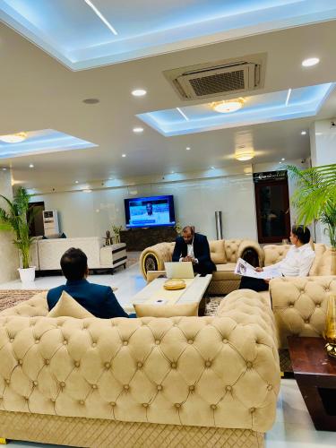 a group of people sitting in a living room with their laptops at Hotel Amayra in Jaipur