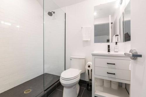 a white bathroom with a toilet and a shower at Luxury Apartment in West Oakland - Near Downtown in Oakland