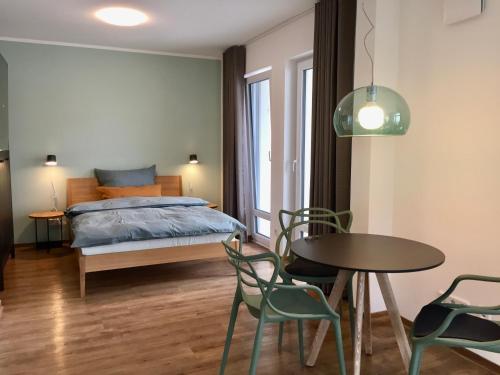 een slaapkamer met een bed en een tafel en stoelen bij aparthaus felizitas in Groß-Gerau