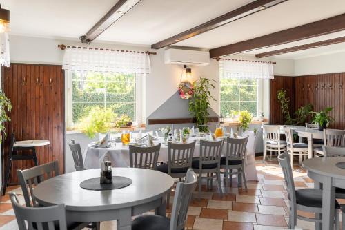 a dining room with tables and chairs and windows at Tawerna "Cicha Przystań" in Zielona Góra