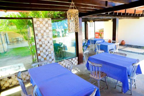 un ristorante con tavoli e sedie blu e una finestra di Waterfront Residence a Maceió