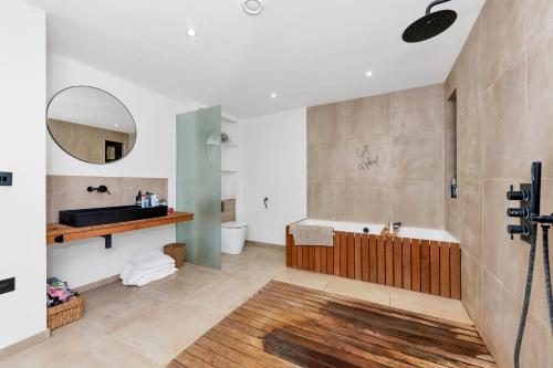 uma casa de banho com uma banheira, um lavatório e um espelho. em House at the heath em Royston