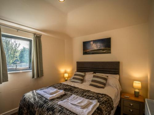 a bedroom with a bed with two towels on it at Lodge With A View in Steyning