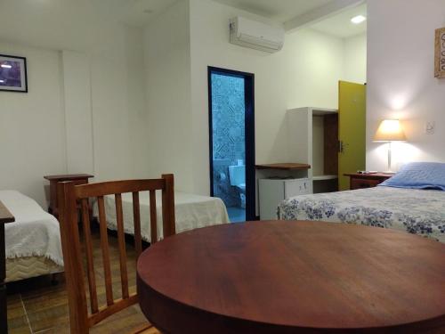 a room with a wooden table and a bed and a table at Tiradentes Pousada Ramalhete in Tiradentes