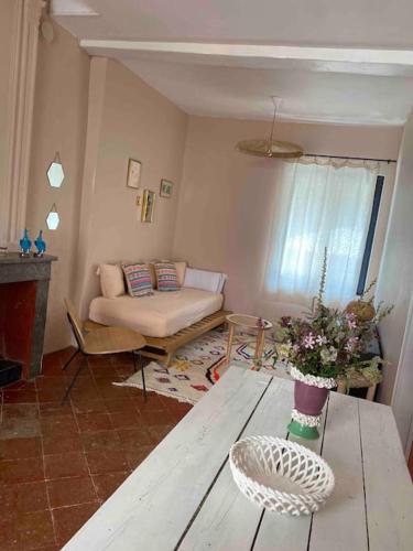 a living room with a table and a couch at Appartement de Charme dans un Ancien Mas Cévenol piscine et jacuzzi in Valleraugue
