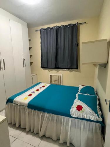 貝倫的住宿－Apartamento em condomínio Belém，一间卧室配有一张带蓝色床单的床和一扇窗户。