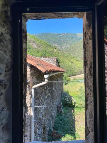 a window of a building with a view of a mountain at Appartement de Charme dans un Ancien Mas Cévenol piscine et jacuzzi in Valleraugue