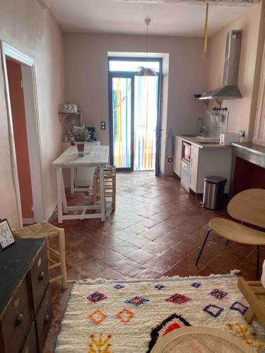 a living room with a table and a kitchen at Appartement de Charme dans un Ancien Mas Cévenol piscine et jacuzzi in Valleraugue