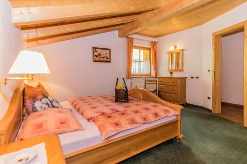 um quarto com uma cama grande e um tecto de madeira em Alpinchalet Apartment Edelweiss 1 em Ortisei