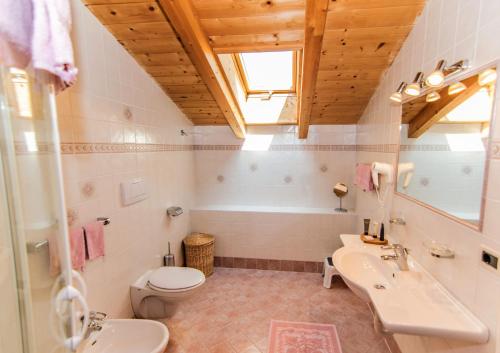 uma casa de banho com um lavatório, um WC e uma banheira em Alpinchalet Apartment Edelweiss 1 em Ortisei