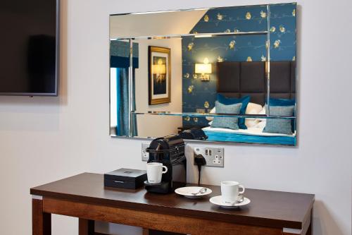 Cette chambre comprend une table avec deux tasses. dans l'établissement Mandolay Hotel Guildford, à Guildford