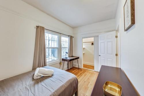 a bedroom with a bed and a table and window at Right Across From Campus 2BR 1b in Berkeley