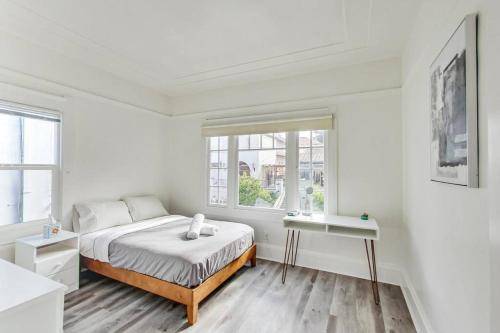 um quarto branco com uma cama e uma janela em Best Location 3BR by UCBerkeley em Berkeley