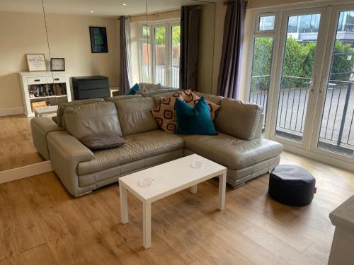 a living room with a couch and a table at Large Luxury appartment in Cobham