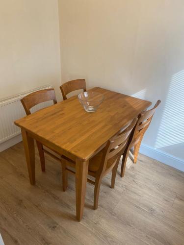 a wooden table with chairs and a bowl on top at Large Luxury appartment in Cobham