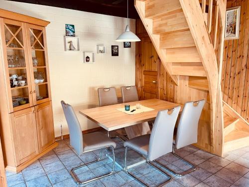 comedor con mesa de madera y sillas en Extertal-Ferienpark - Premium-Ferienhaus Sonnenschein #56a, en Extertal