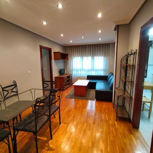 sala de estar con sofá y mesa en Apartamento Coqueto 10min centro en Oviedo