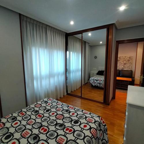 um quarto com uma cama e um espelho grande em Apartamento Coqueto 10min centro em Oviedo