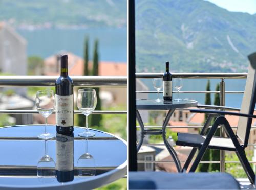 a bottle of wine and two glasses on a table at Pearl Shell Apartments in Kotor