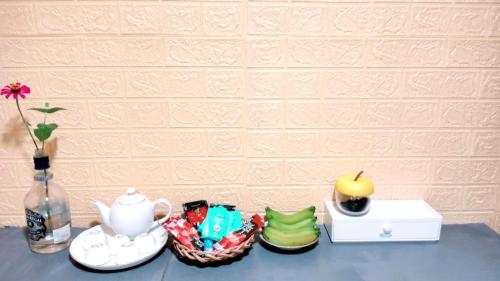 a table with a vase and a tea pot and a candle at Coco Happy Farm in Ben Tre