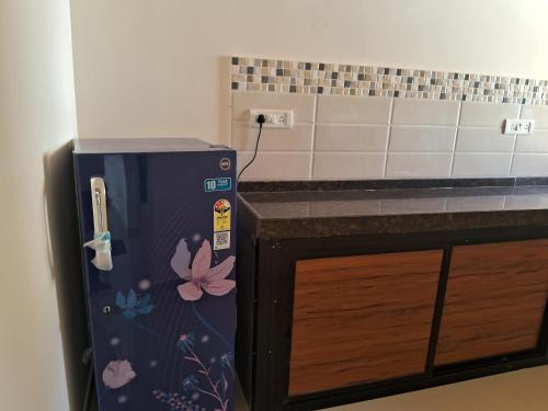 a kitchen with a purple refrigerator next to a counter at Fieldstone Lovely 2 BHK AC Apartment in Talaulim