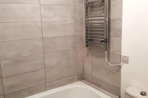 a bathroom with a shower with a tub and a toilet at Ardara Town centre 2 Bed Apt in Donegal