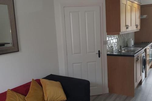 a kitchen with a door leading into a kitchen with a sink at Ardara Town centre 2 Bed Apt in Donegal
