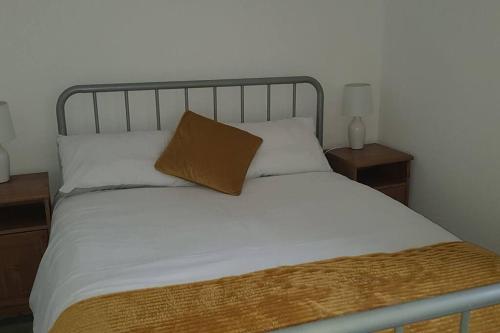 a bed with a metal headboard and a pillow on it at Ardara Town centre 2 Bed Apt in Donegal
