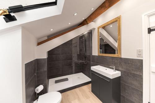 a bathroom with a sink toilet and a mirror at Rose Barn in Hawkshead