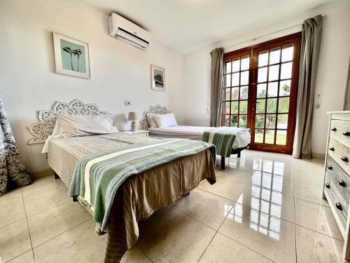 une chambre avec deux lits et une fenêtre dans l'établissement Great Escape, Golf del Sur, à San Miguel de Abona